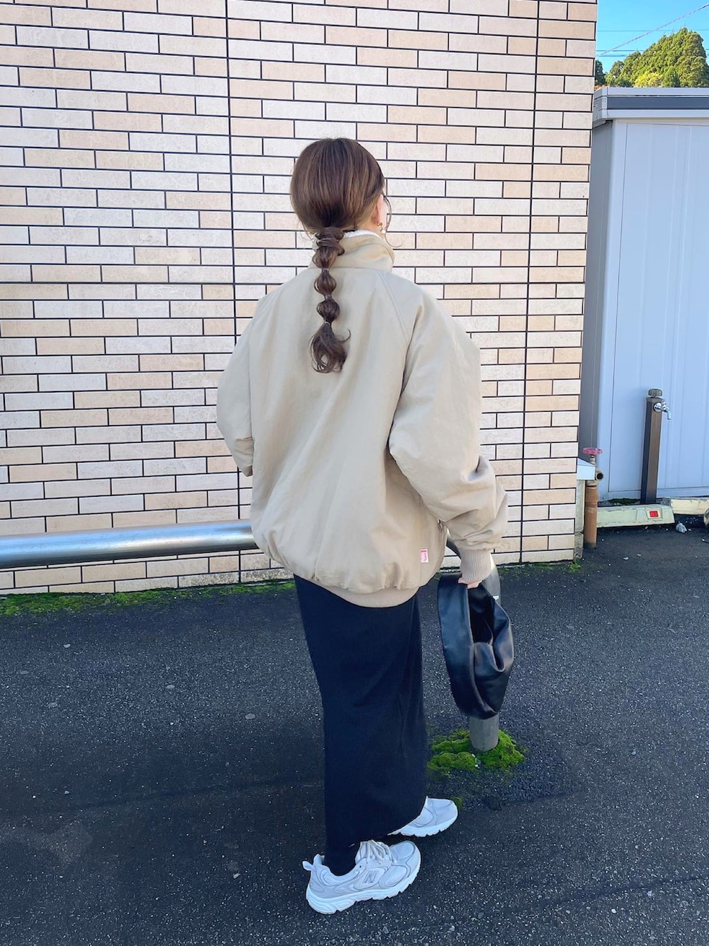 ベージュ系のブルゾン、ホワイト系のニット/セーター、ホワイト系のスニーカーを着用したレディースの冬コーディネートの3枚目の写真