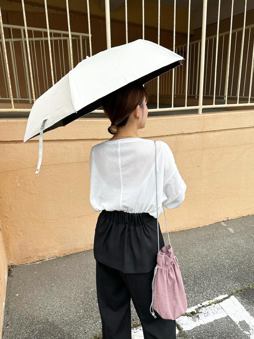 ホワイト系のTシャツ/カットソー、ブラック系のその他パンツ、ホワイト系のシューズを着用したレディースの春コーディネートの5枚目の写真