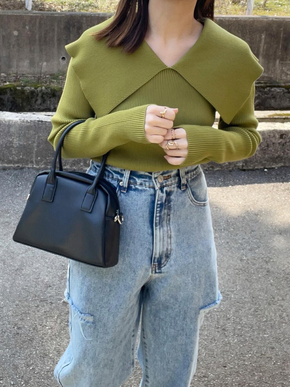 グリーン系のニット/セーター、その他のデニムパンツ、ブラック系のボストンバッグを着用したレディースの春コーディネートの2枚目の写真