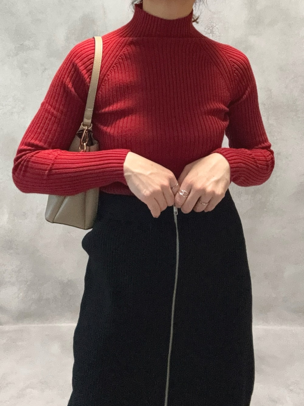 レッド系のニット/セーター、ブルー系のデニムジャケット、ブラック系のスカートを着用したレディースの秋コーディネートの2枚目の写真