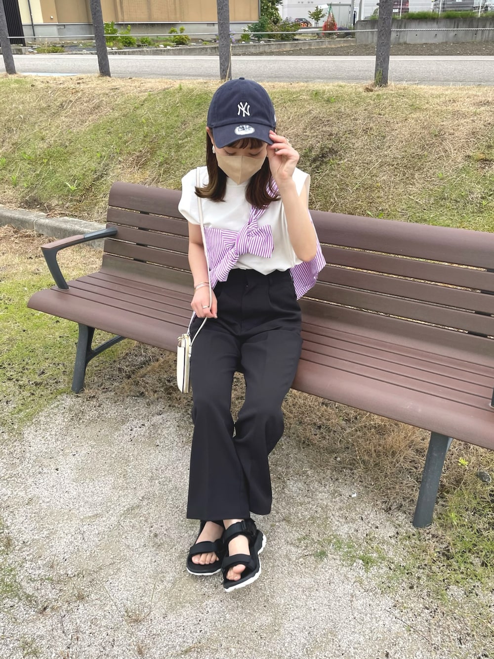 ピンク系のシャツ/ブラウス、ホワイト系のニット/セーター、ブラック系のスラックスを着用したレディースの夏コーディネートの2枚目の写真