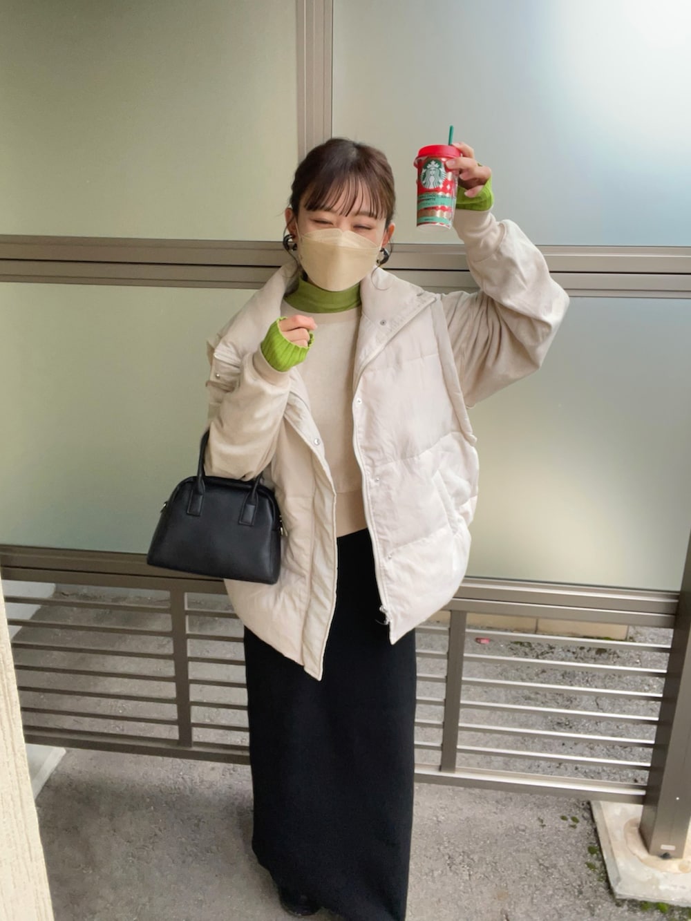 ベージュ系のスウェット、グリーン系のニット/セーター、ホワイト系のダウンベストを着用したレディースの秋コーディネートの4枚目の写真