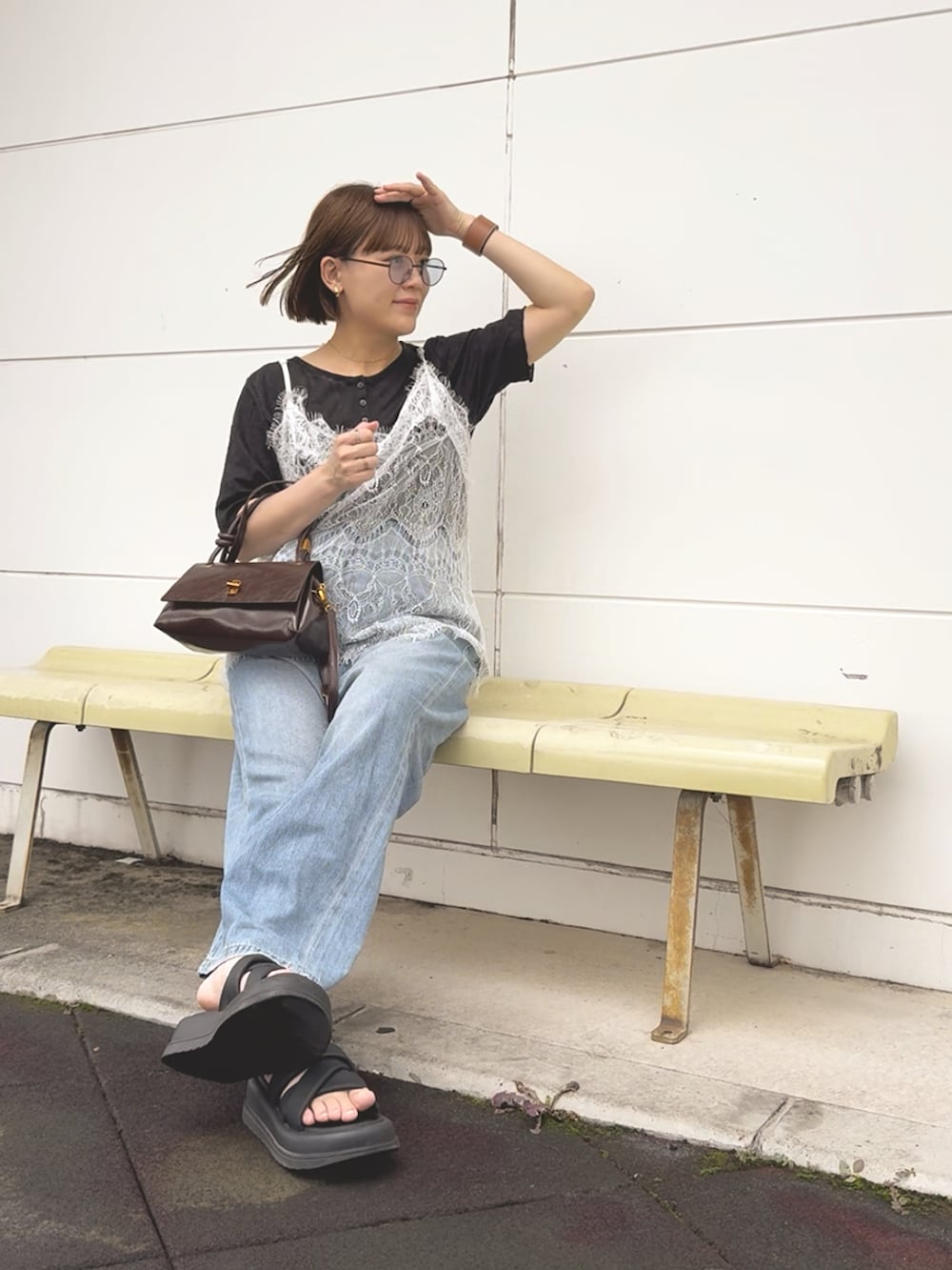 ホワイト系のキャミソール、ブラック系のTシャツ/カットソー、ブルー系のデニムパンツを着用したレディースの夏コーディネートの4枚目の写真