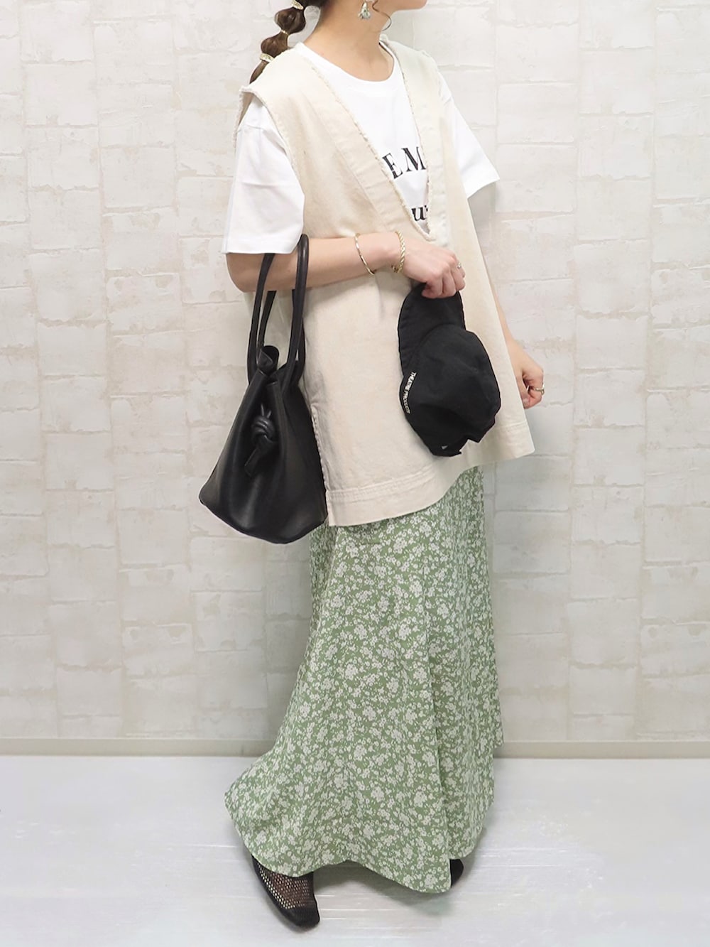 グリーン系のスカート、ホワイト系のTシャツ/カットソー、ホワイト系のベストを着用したレディースの春コーディネートの5枚目の写真