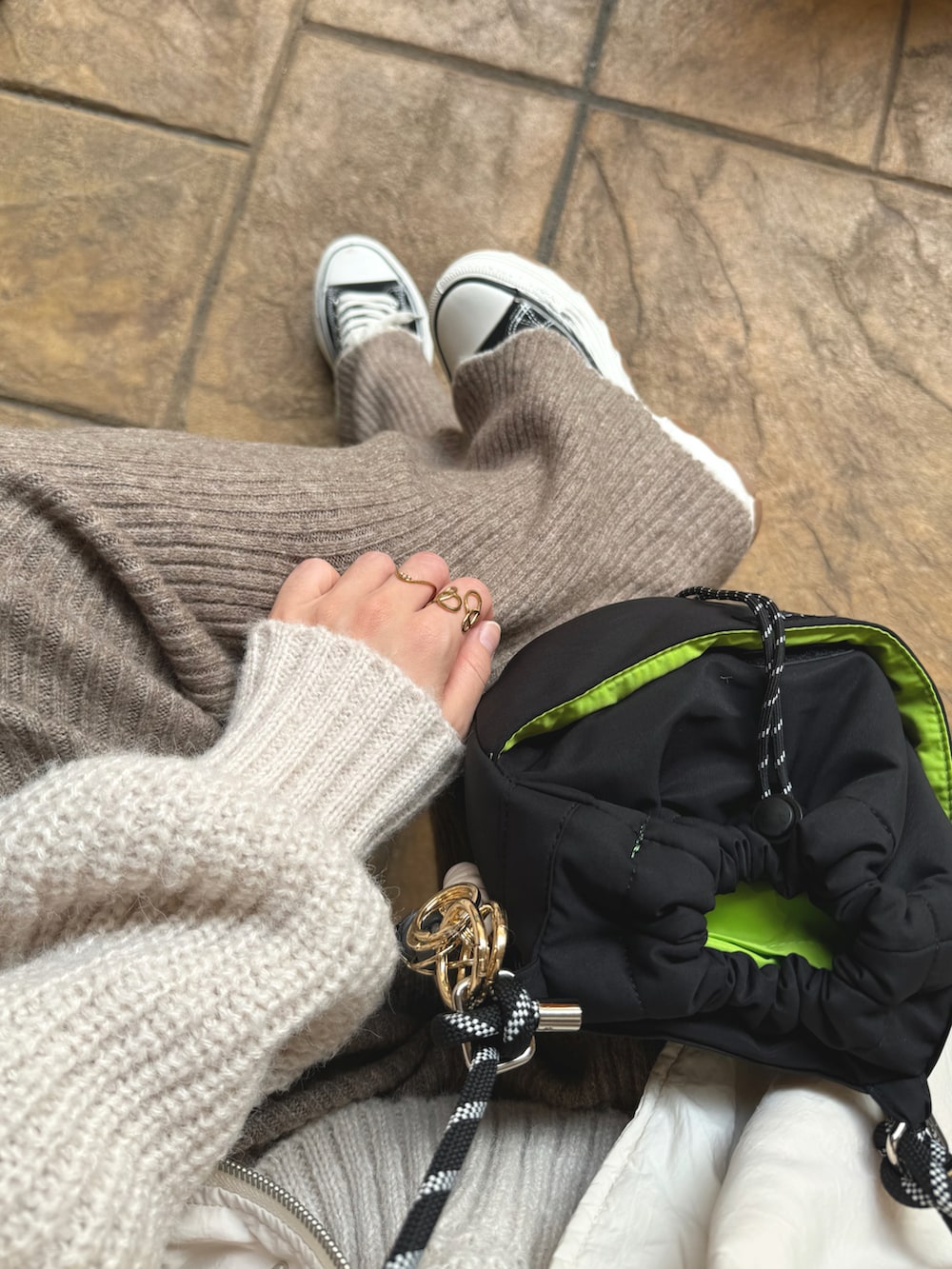 ホワイト系のダウンジャケット/コート、ブラウン系のその他パンツ、ホワイト系のニット/セーターを着用したレディースの秋コーディネートの3枚目の写真