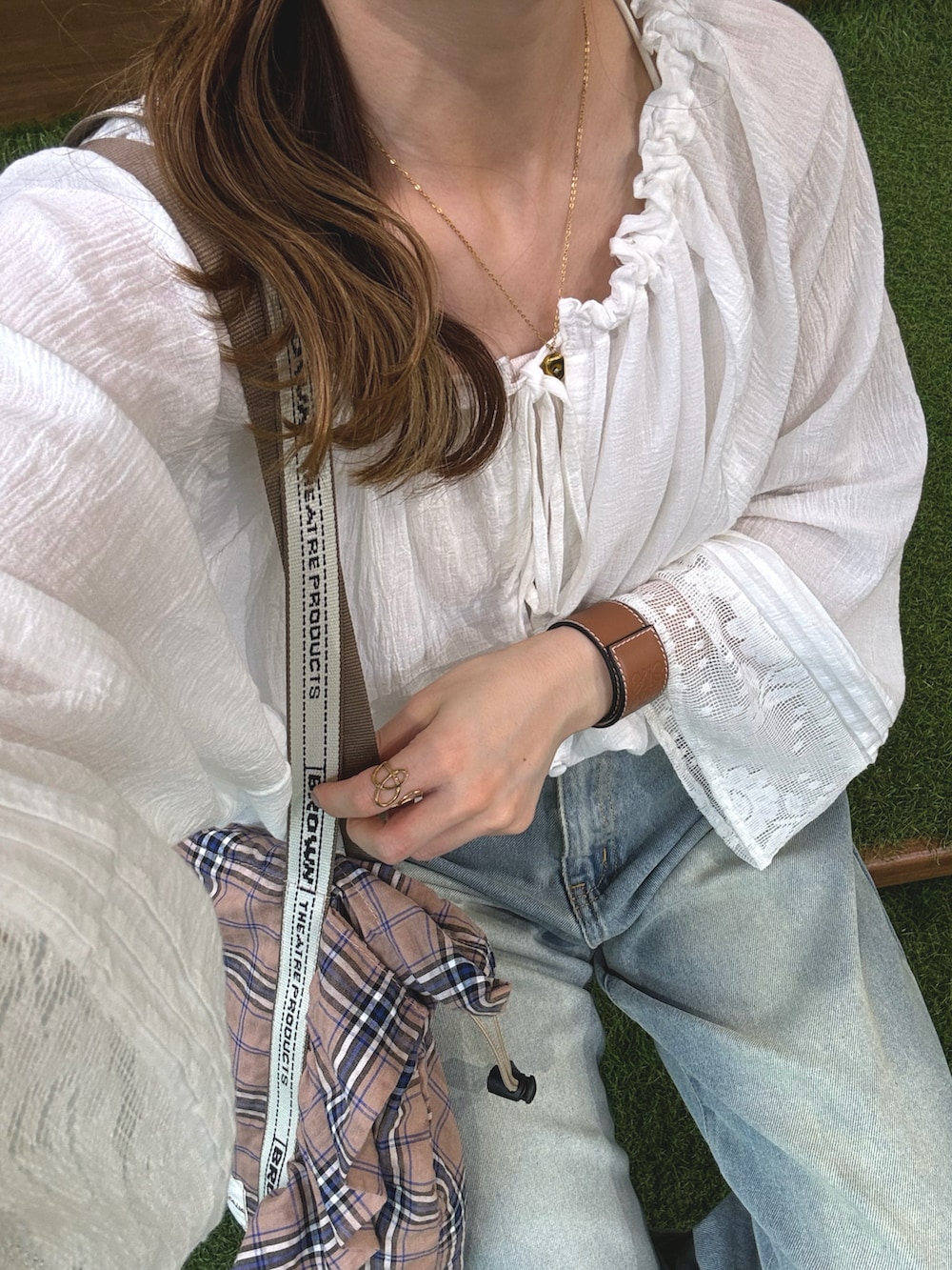 ホワイト系のトップス、ブルー系のデニムパンツ、ピンク系のトートバッグを着用したレディースの春コーディネートの4枚目の写真