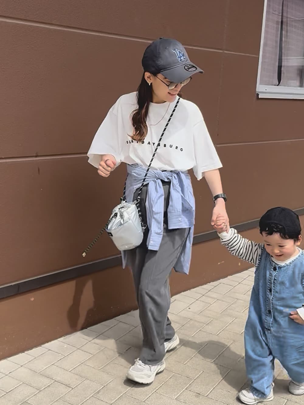 ホワイト系のTシャツ/カットソー、ベージュ系のスニーカー、ブルー系のシャツ/ブラウスを着用したレディースの夏コーディネートの2枚目の写真