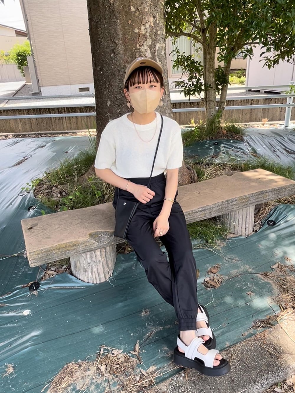 ホワイト系のニット/セーター、ブラック系のその他パンツ、ブラック系のショルダーバッグを着用したレディースの夏コーディネートの2枚目の写真