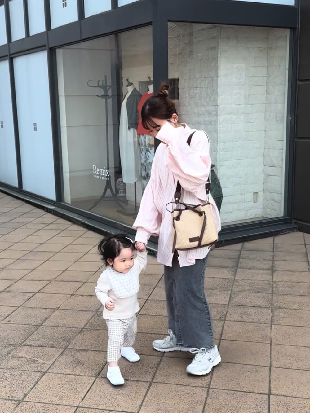 ピンク系のシャツ/ブラウス、ブラック系のデニムスカート、ブラウン系のトートバッグを着用したレディースの春コーディネートの2枚目の写真