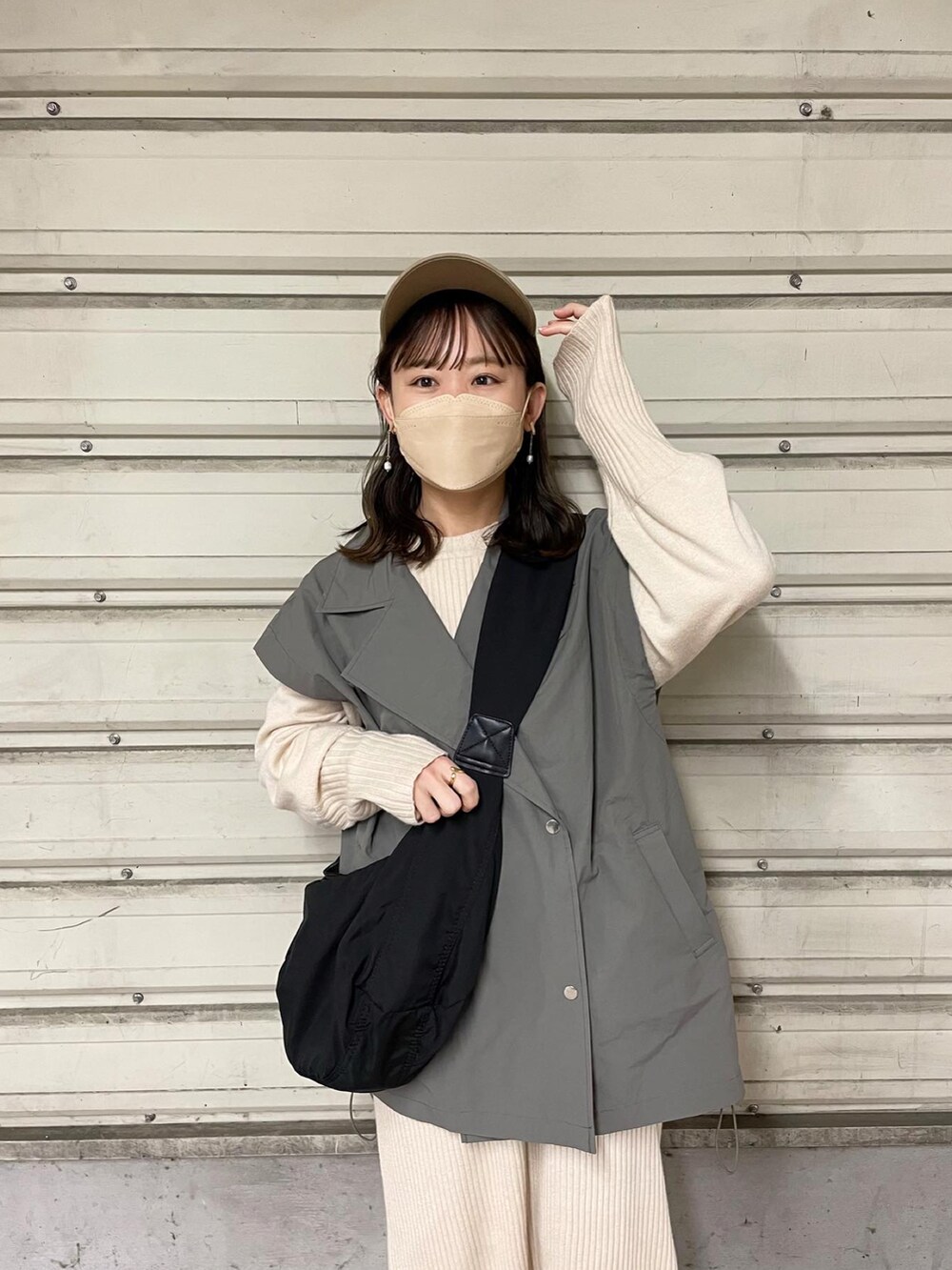 グレー系のミリタリージャケット、ホワイト系のワンピース、ブラック系のショルダーバッグを着用したレディースの春コーディネートの4枚目の写真