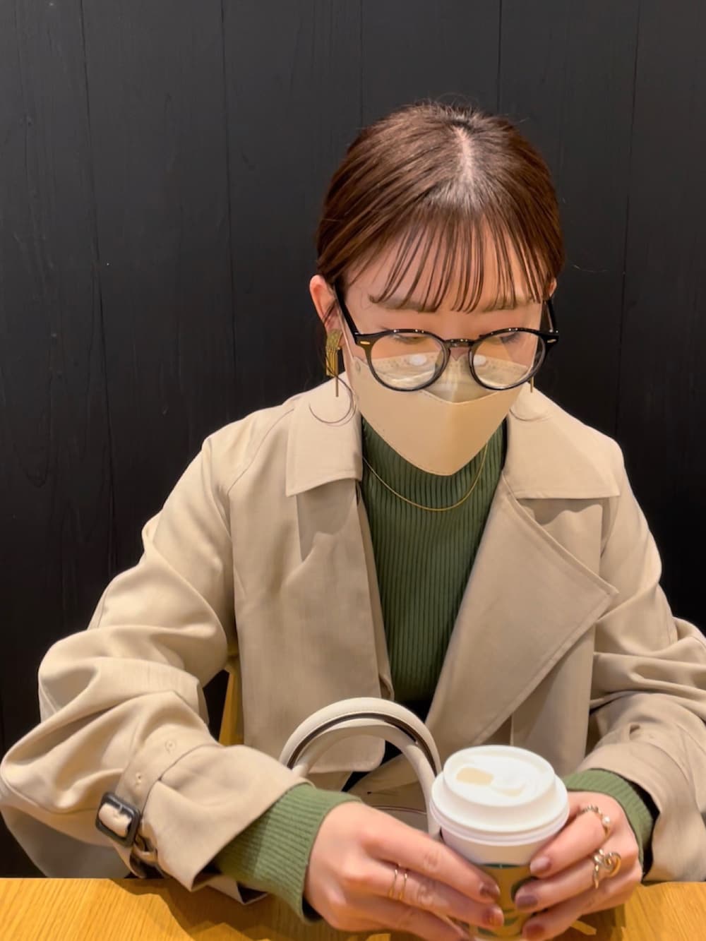 ホワイト系のハンドバッグ、グリーン系のニット/セーター、ベージュ系のトレンチコートを着用したレディースの冬コーディネートの4枚目の写真