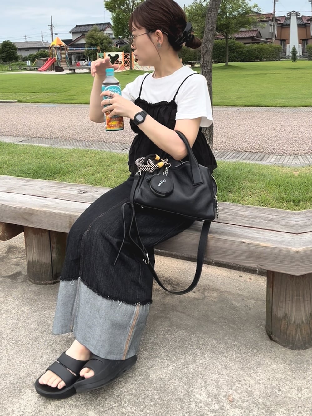 ブラック系のサンダル、ブラック系のボストンバッグ、ブラック系のデニムスカートを着用したレディースの夏コーディネートの4枚目の写真