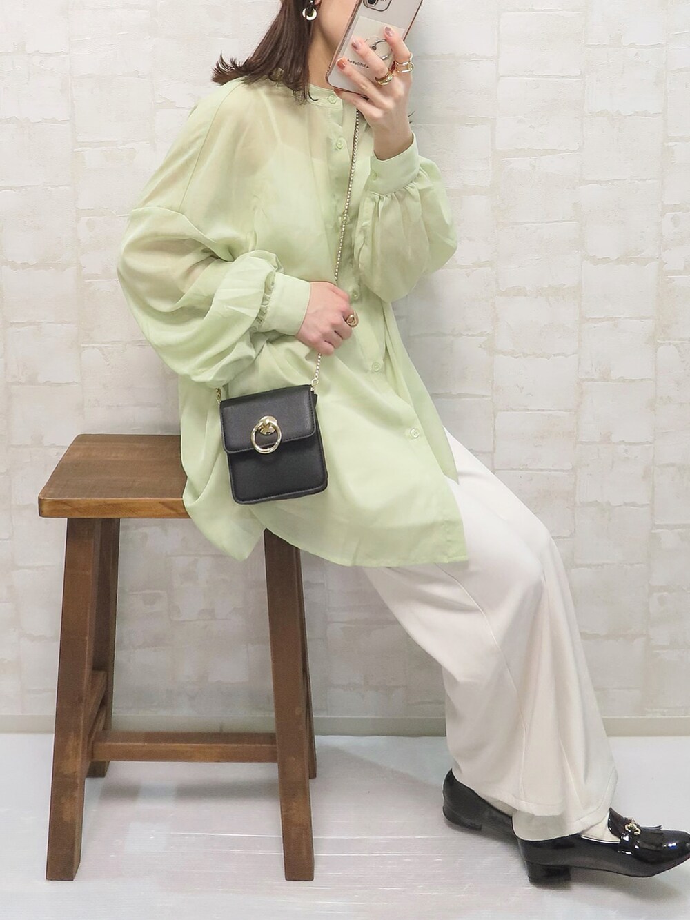グリーン系のシャツ/ブラウス、ホワイト系のその他パンツ、ブラック系のショルダーバッグを着用したレディースの春コーディネートの2枚目の写真