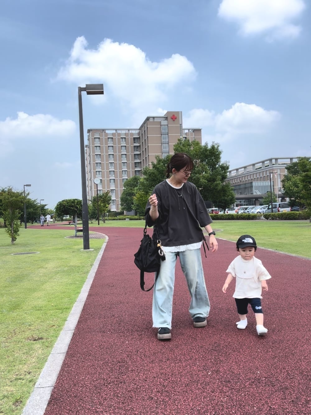 グレー系のTシャツ/カットソー、ブルー系のデニムパンツ、ブラック系のスニーカーを着用したレディースの夏コーディネートの3枚目の写真