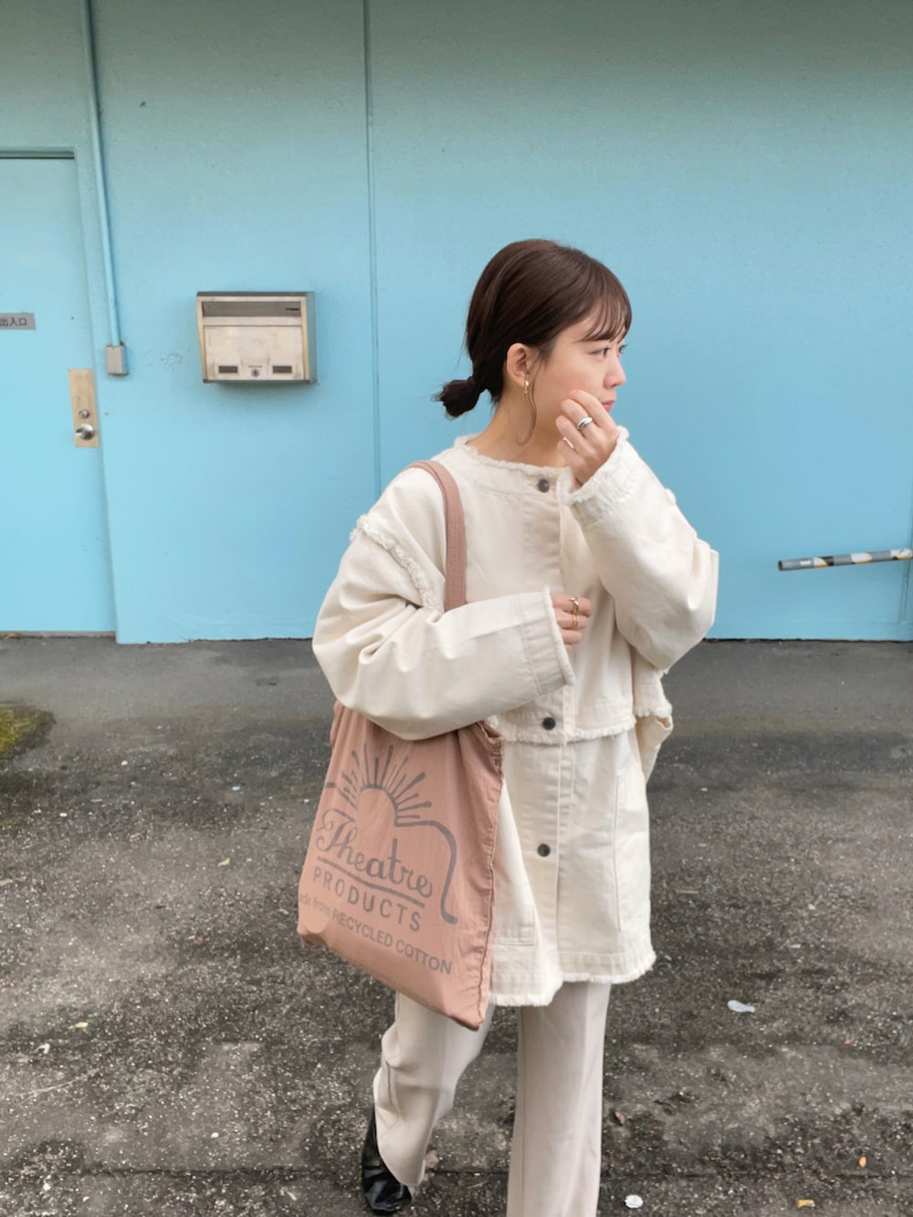 ピンク系のトートバッグ、ホワイト系のデニムジャケット、ホワイト系のスラックスを着用したレディースの春コーディネートの5枚目の写真