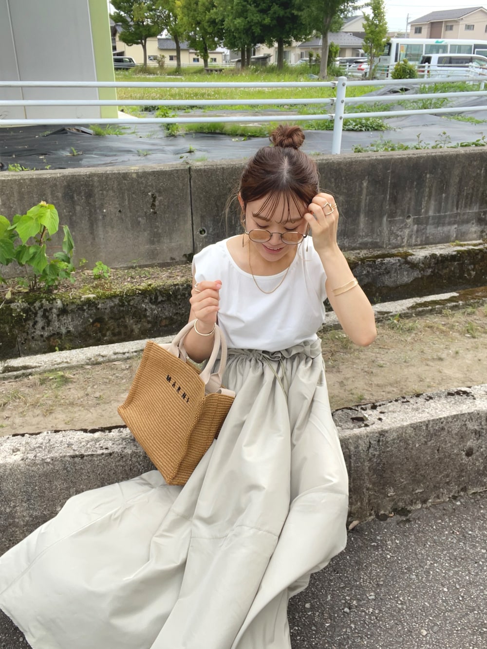 グリーン系のワンピース、ベージュ系のショルダーバッグ、ホワイト系のサンダルを着用したレディースの夏コーディネートの2枚目の写真