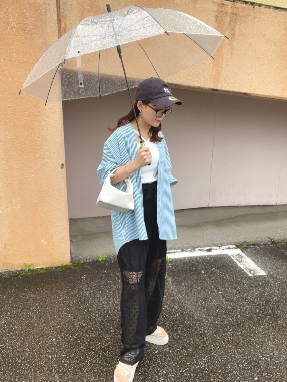 グリーン系のシャツ/ブラウス、ブラック系のその他パンツ、ホワイト系のキャミソールを着用したレディースの春コーディネートの5枚目の写真
