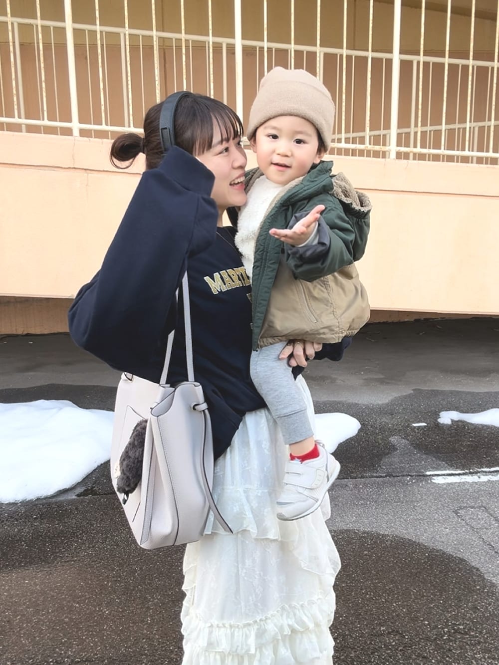 ホワイト系のスカート、ブルー系のスウェット、ホワイト系のバッグを着用したレディースの春コーディネートの3枚目の写真