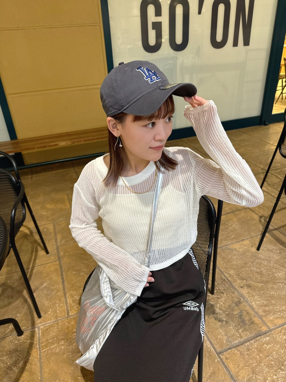 ホワイト系のトップス、ブラック系のスカート、シルバー系のトートバッグを着用したレディースの春コーディネートの4枚目の写真