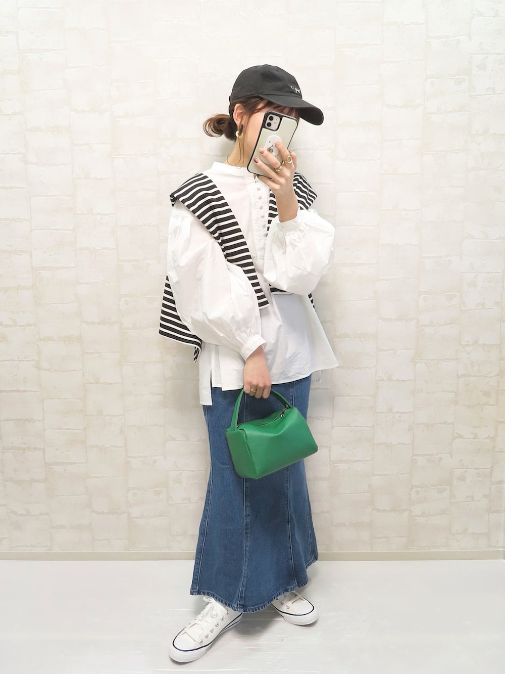 ブルー系のデニムスカート、ベージュ系のトレンチコート、ホワイト系のシャツ/ブラウスを着用したレディースの冬コーディネートの2枚目の写真