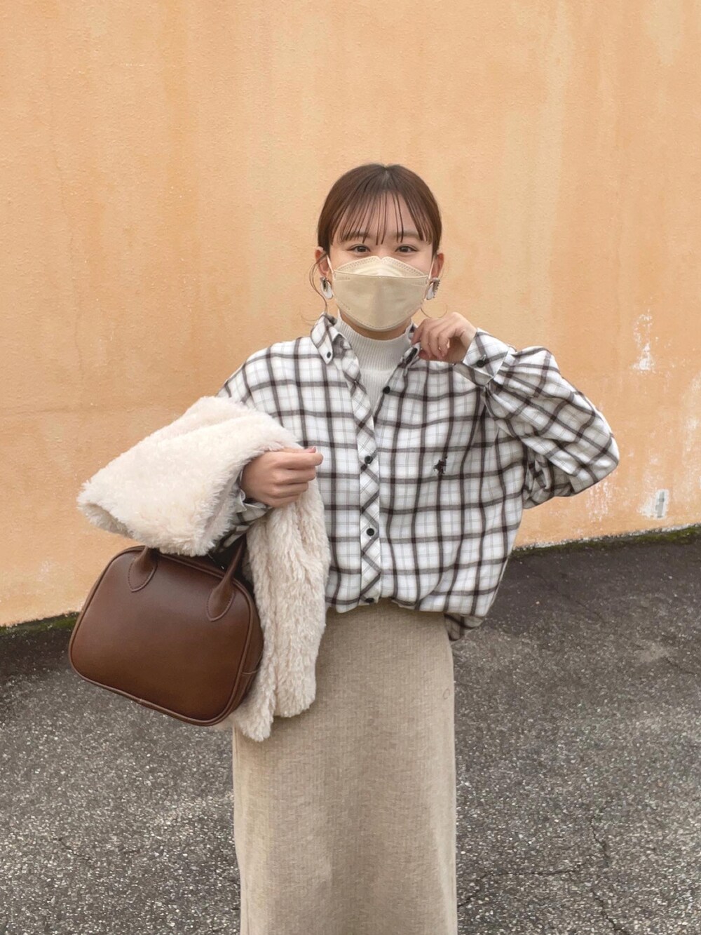 ホワイト系のシャツ/ブラウス、ホワイト系のニット/セーター、グレー系のベストを着用したレディースの冬コーディネートの3枚目の写真