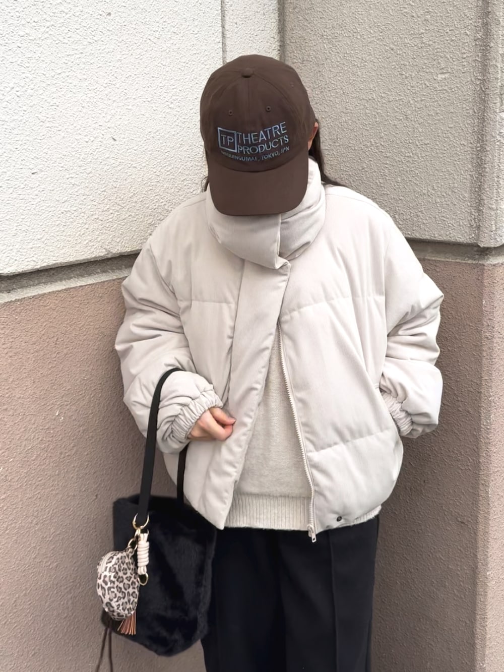 ホワイト系のニット/セーター、ホワイト系のジャケット/アウター、ブラック系のパンツを着用したレディースの冬コーディネートの2枚目の写真