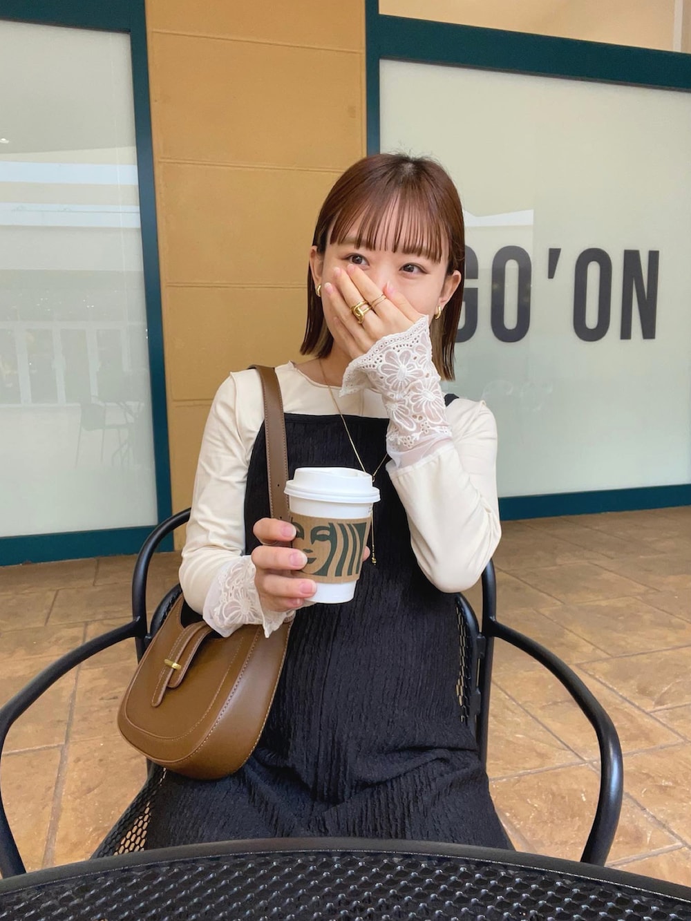 ベージュ系のTシャツ/カットソー、ブラック系のワンピース/ドレス、ブラウン系のバッグを着用したレディースの秋コーディネートの3枚目の写真