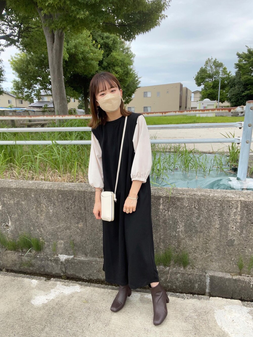 ブラック系のワンピース、ブラウン系のブーツ、ブラウン系のハットを着用したレディースの秋コーディネートの2枚目の写真