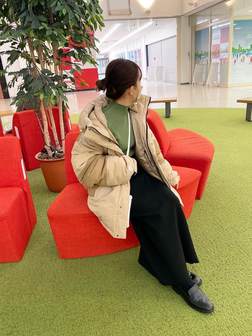 ベージュ系のダウンジャケット/コート、グリーン系のニット/セーター、ブラック系のスカートを着用したレディースの冬コーディネートの4枚目の写真