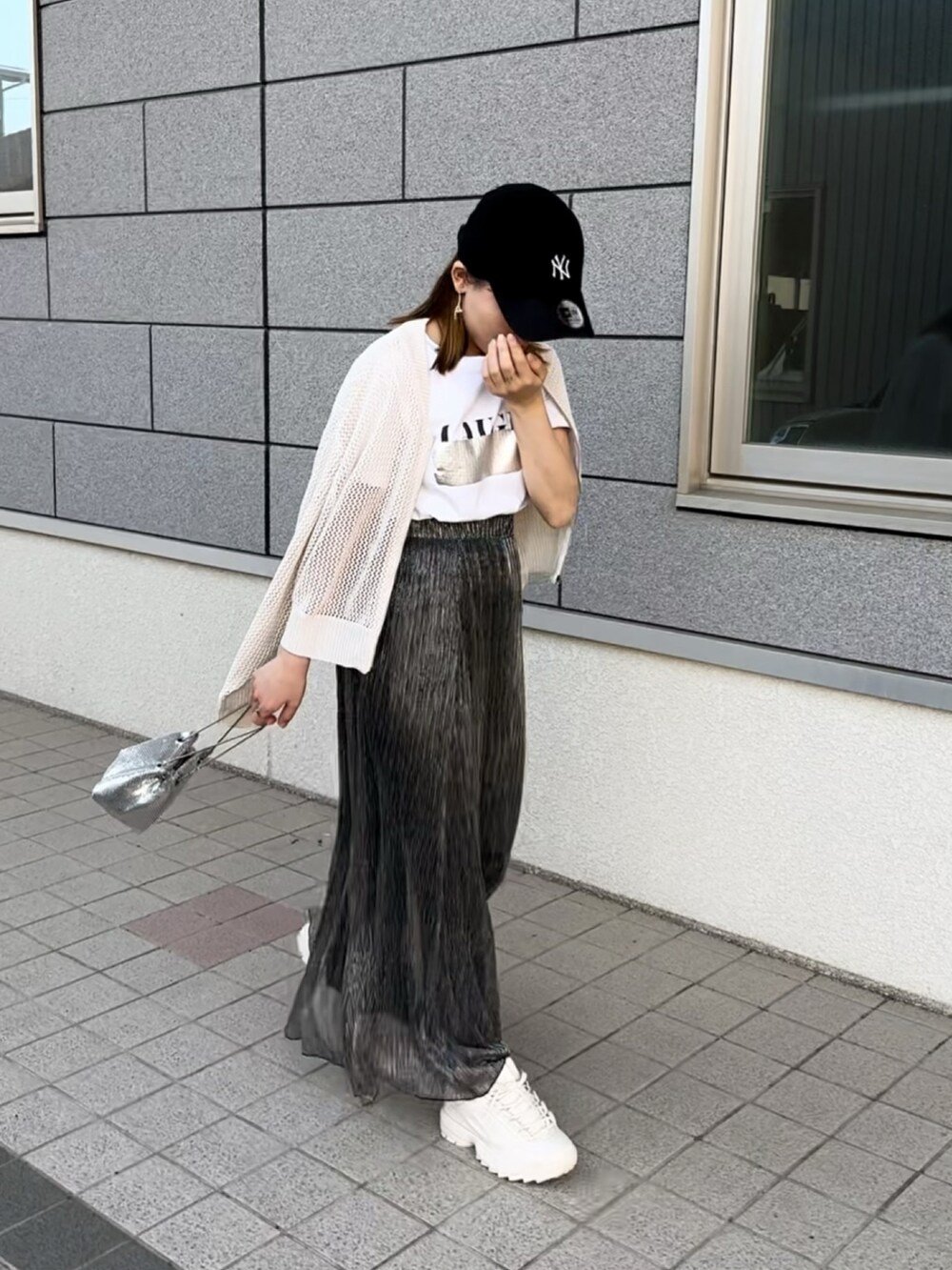 ホワイト系のTシャツ/カットソー、ブラック系のスカート、ホワイト系のカーディガン/ボレロを着用したレディースの夏コーディネートの3枚目の写真