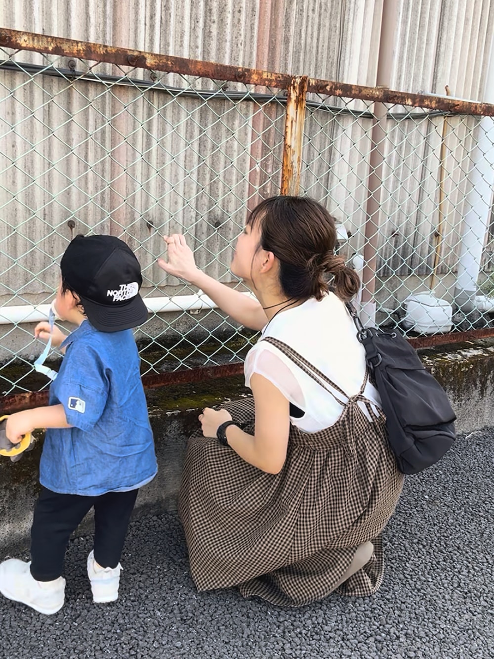 ブラウン系のワンピース、ホワイト系のトップス、ブラック系のバッグを着用したレディースの秋コーディネートの4枚目の写真