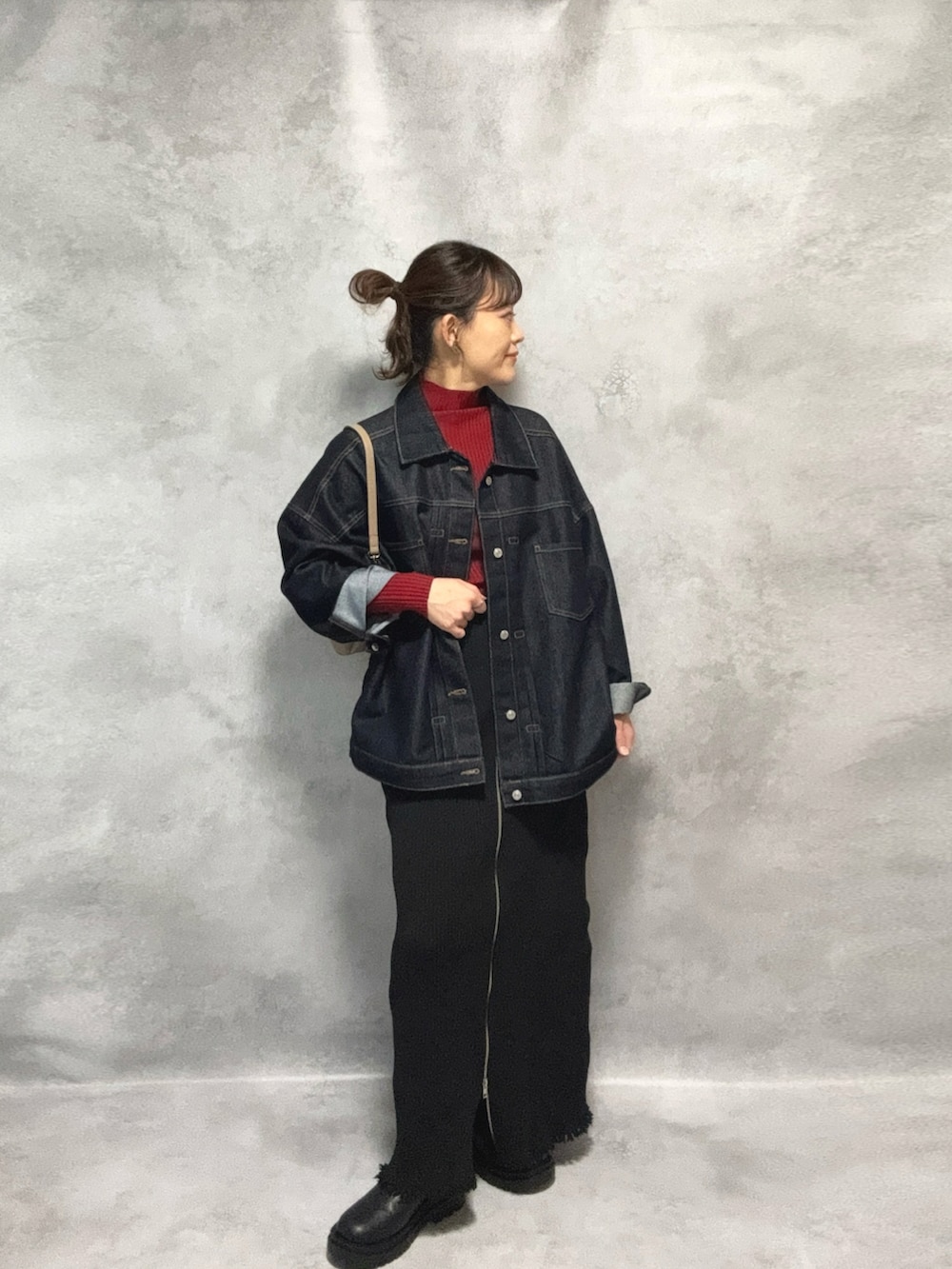 レッド系のニット/セーター、ブルー系のデニムジャケット、ブラック系のスカートを着用したレディースの秋コーディネートの4枚目の写真