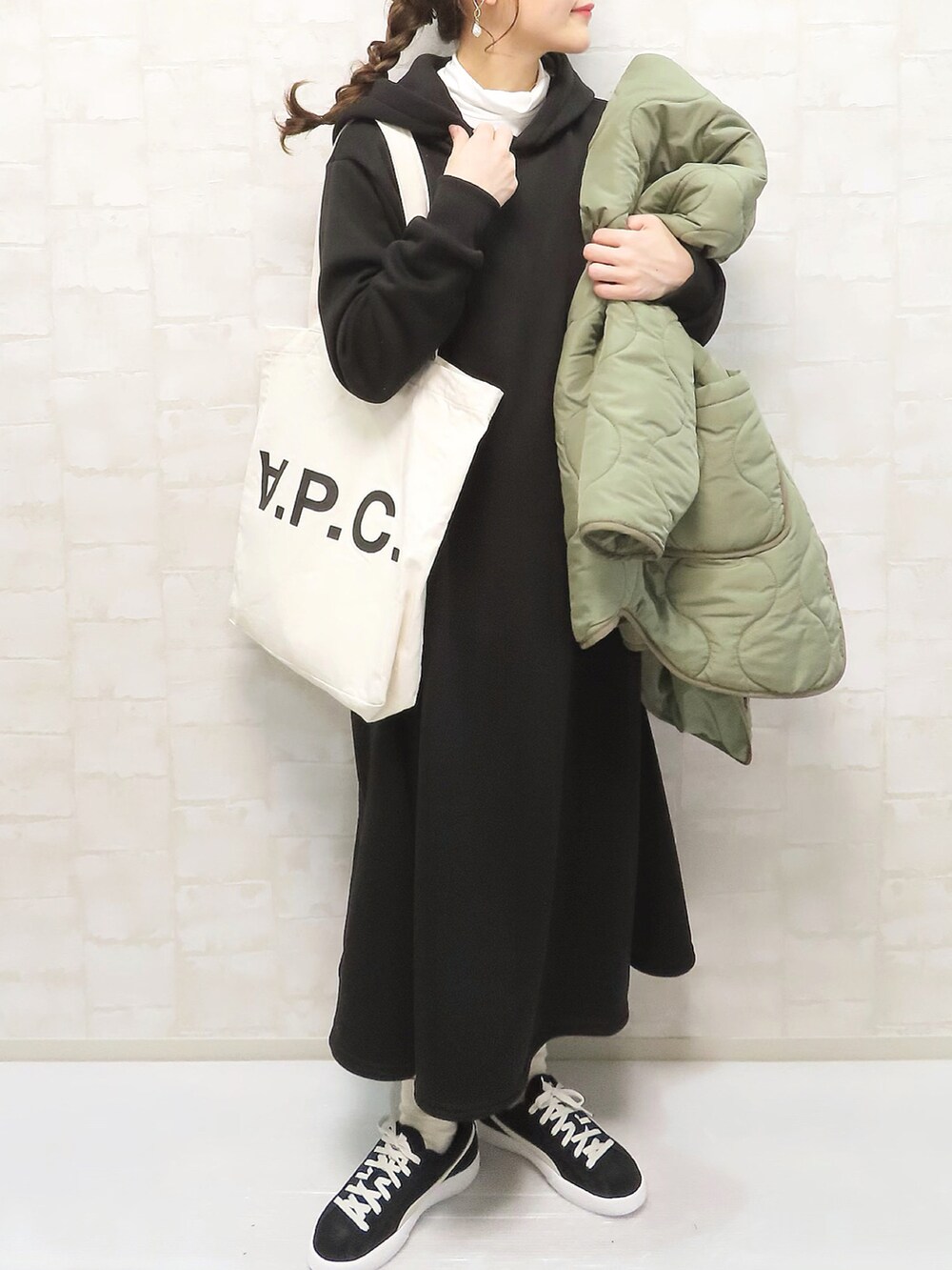 ブラック系のワンピース、ホワイト系のトップス、グリーン系のノーカラージャケットを着用したレディースの冬コーディネートの2枚目の写真