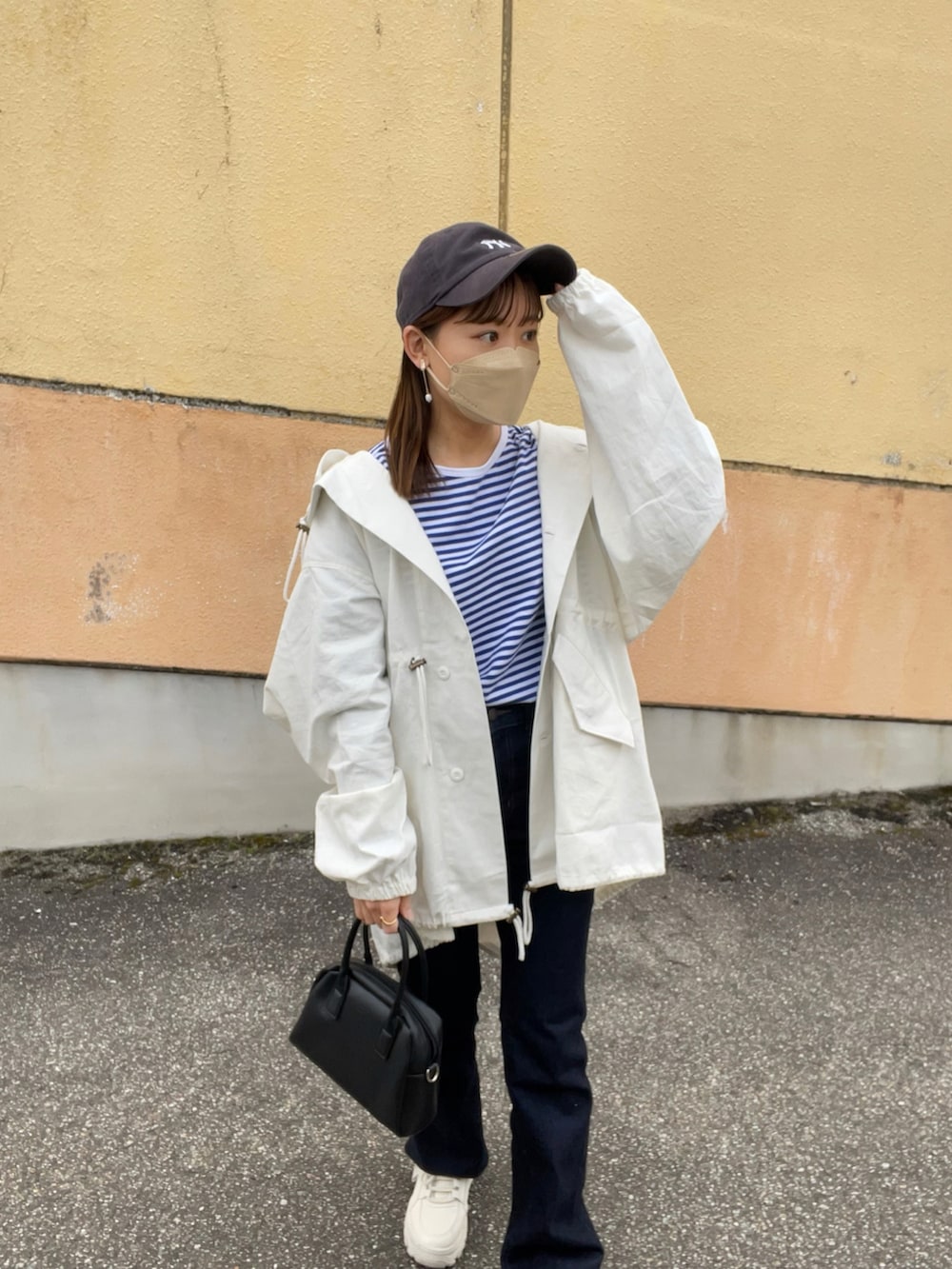 ブルー系のTシャツ/カットソー、ホワイト系のモッズコート、ブルー系のデニムパンツを着用したレディースの春コーディネートの3枚目の写真