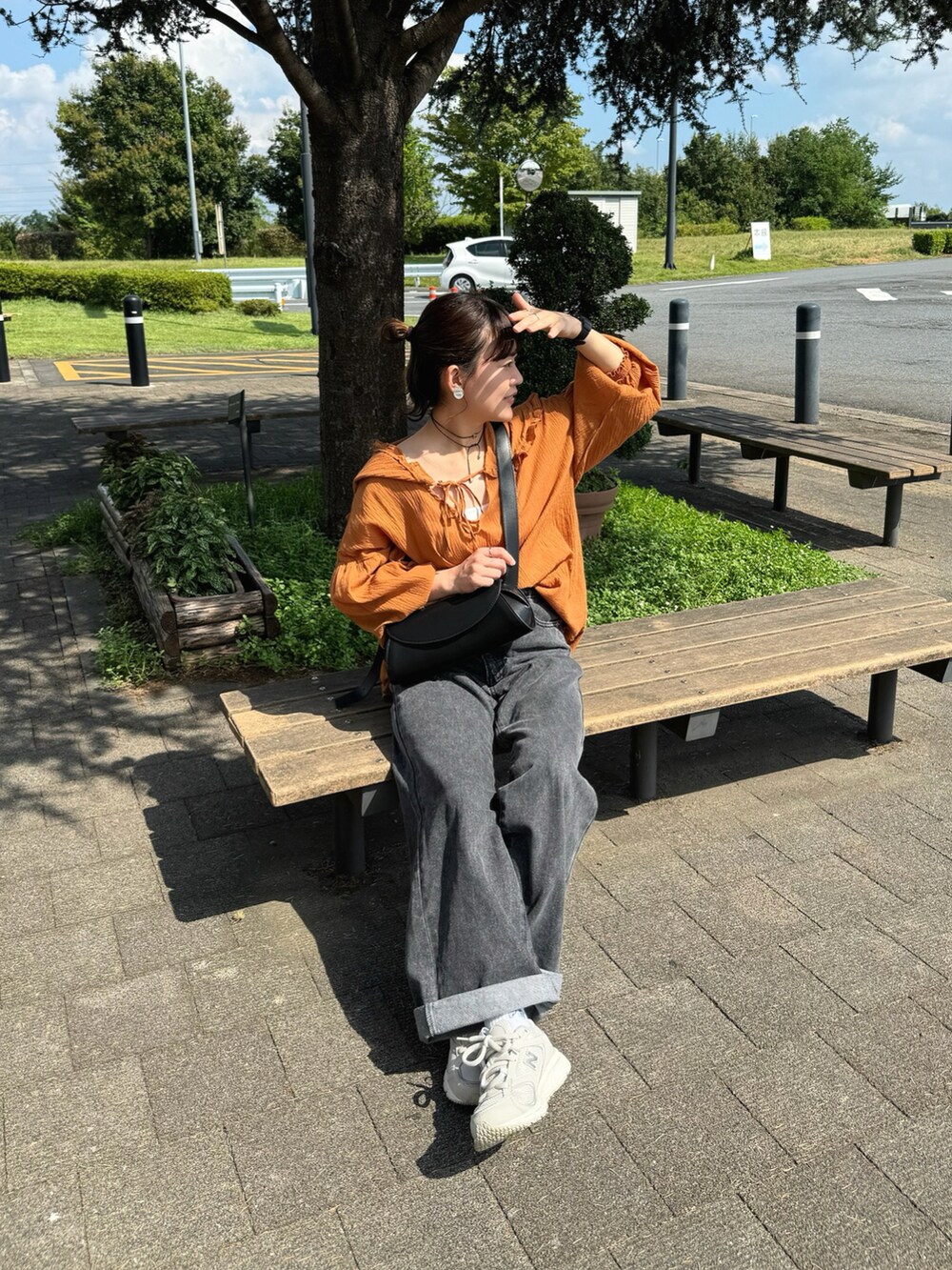 ブラウン系のシャツ/ブラウス、ブラック系のデニムパンツ、ブラック系のショルダーバッグを着用したレディースの秋コーディネートの4枚目の写真