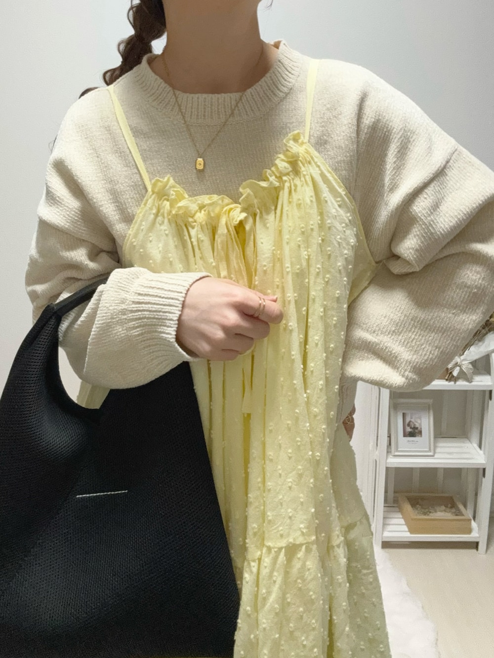 イエロー系のワンピース、ブルー系のデニムパンツ、ベージュ系のスニーカーを着用したレディースの冬コーディネートの5枚目の写真