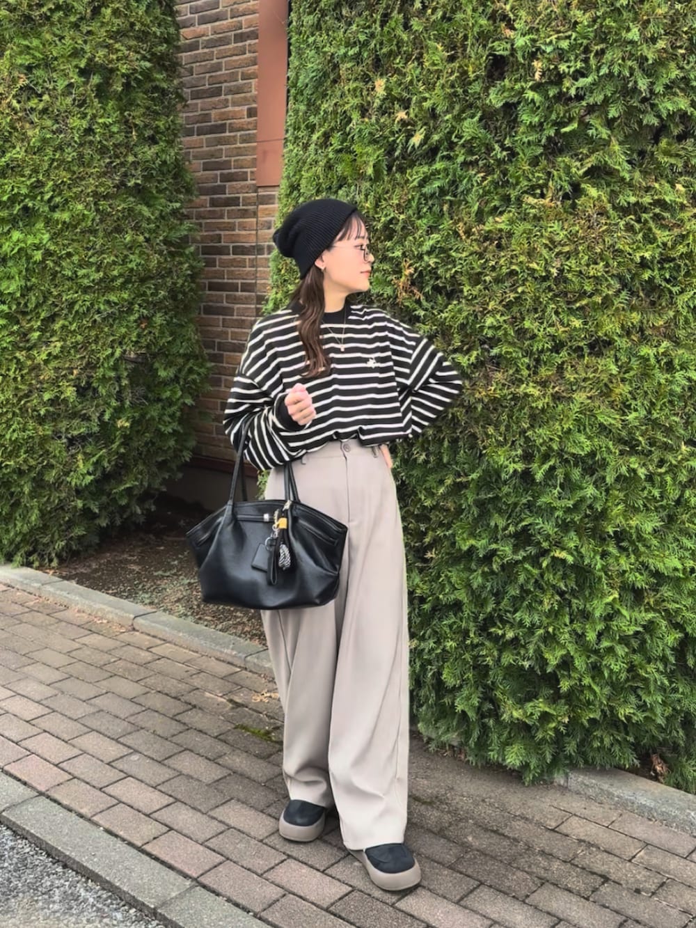 ベージュ系のその他パンツ、ブラック系のTシャツ/カットソー、ブラック系のバッグを着用したレディースの秋コーディネートの4枚目の写真