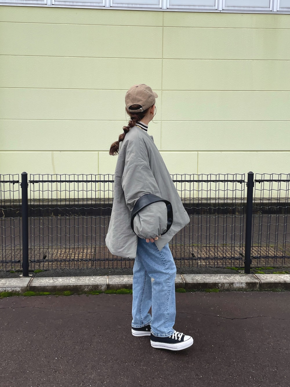 グリーン系のノーカラージャケット、ホワイト系のトップス、ブルー系のデニムパンツを着用したレディースの冬コーディネートの2枚目の写真