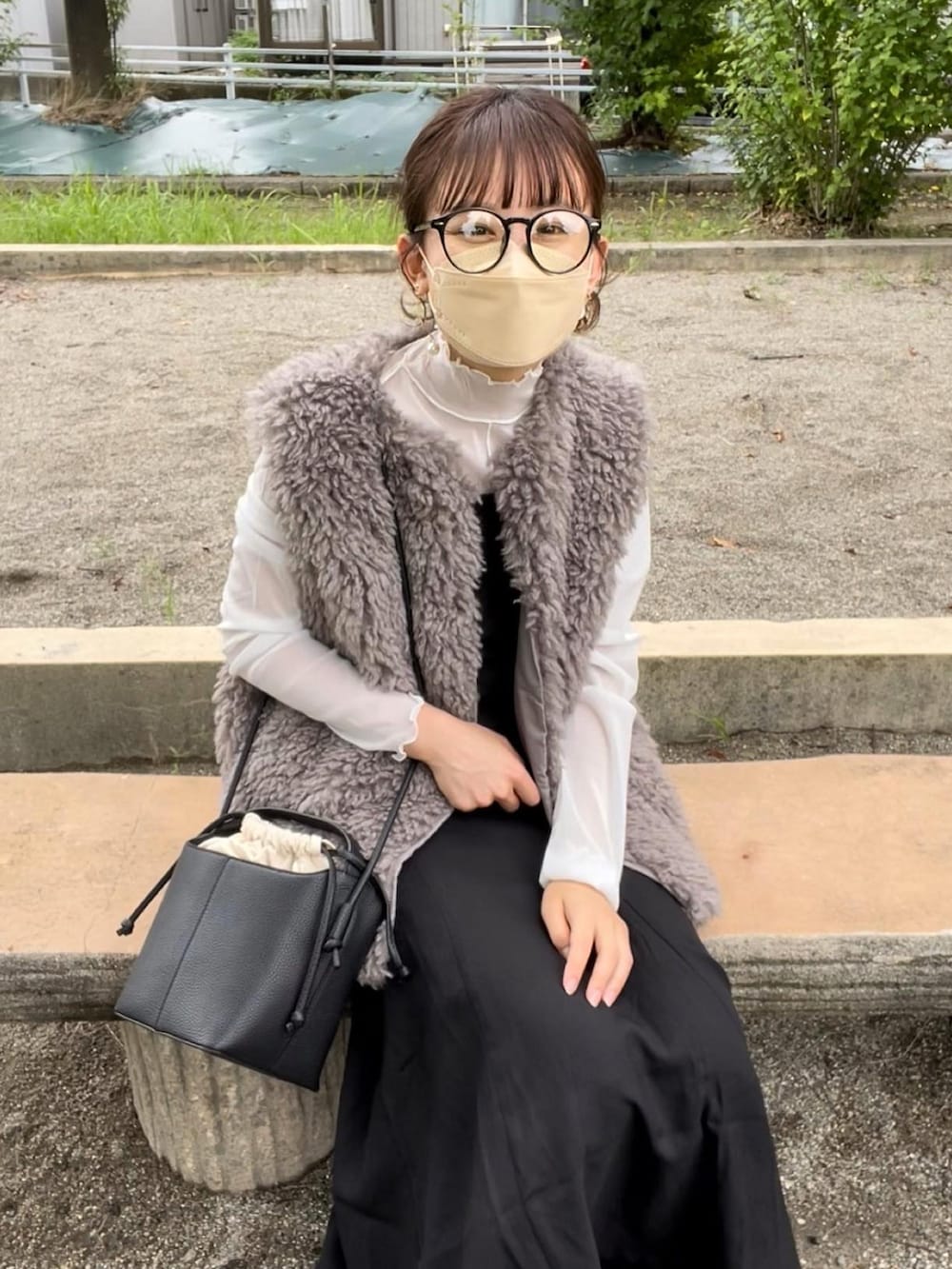 ベージュ系のベスト、ホワイト系のTシャツ/カットソー、ブラック系のジャンパースカートを着用したレディースの秋コーディネートの5枚目の写真