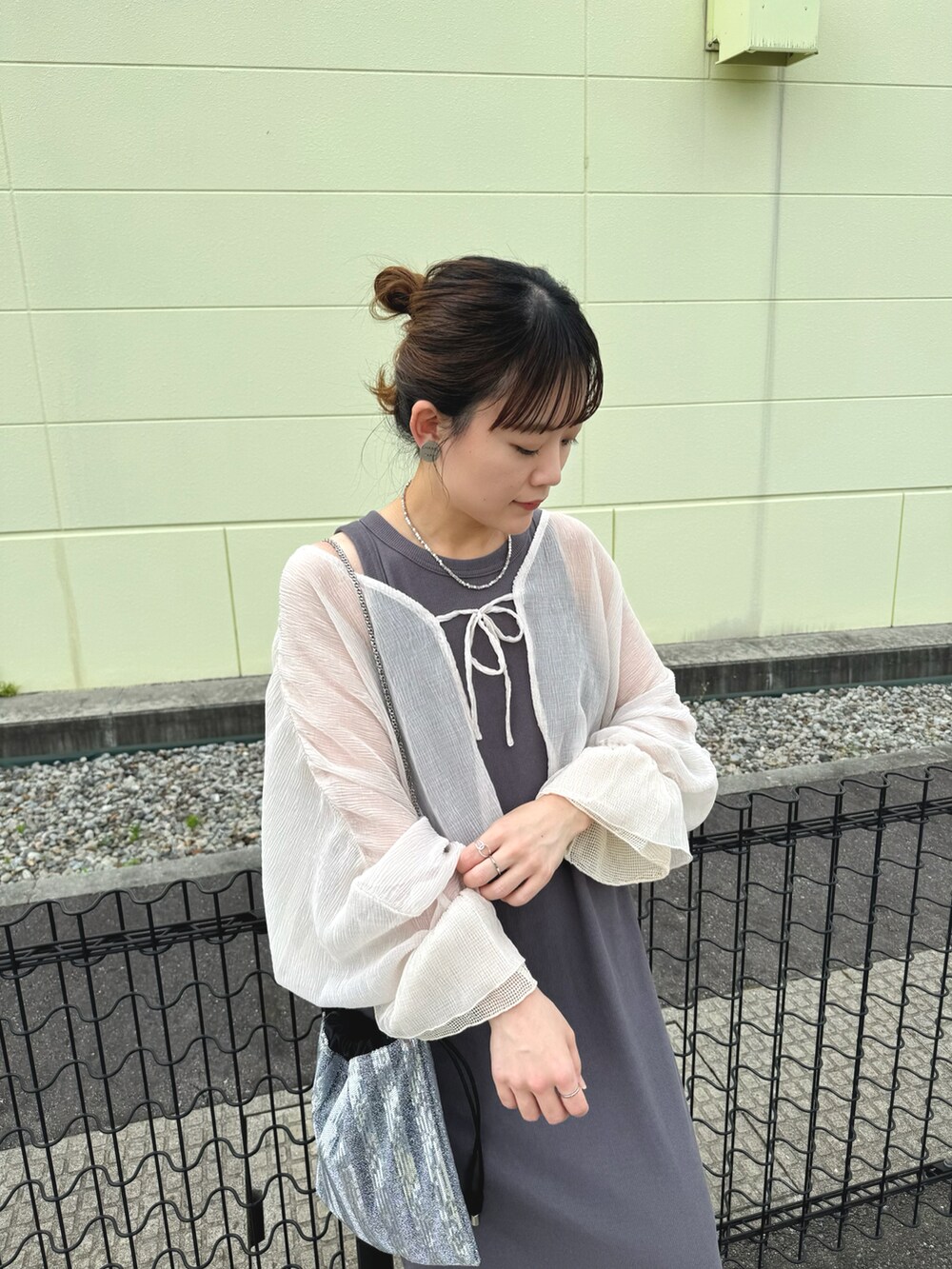 ベージュ系のカーディガン/ボレロ、シルバー系のショルダーバッグ、ブラック系のサンダルを着用したレディースの夏コーディネートの3枚目の写真