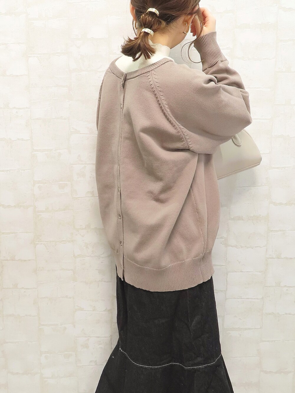 ベージュ系のカーディガン/ボレロ、ブラック系のスカート、ベージュ系のショルダーバッグを着用したレディースの冬コーディネートの4枚目の写真