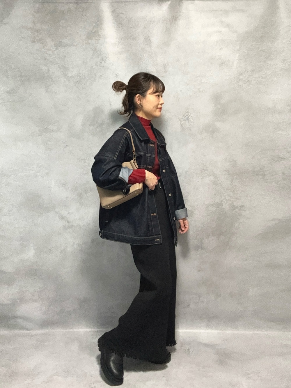 レッド系のニット/セーター、ブルー系のデニムジャケット、ブラック系のスカートを着用したレディースの秋コーディネートの3枚目の写真