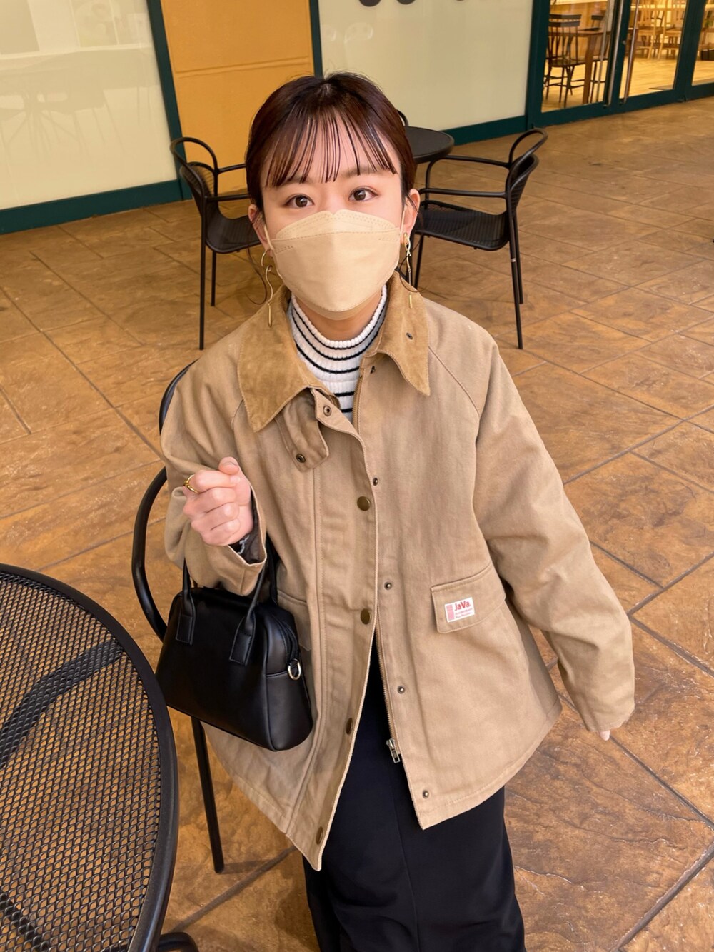ベージュ系のブルゾン、ホワイト系のニット/セーター、ブラック系のスカートを着用したレディースの春コーディネートの4枚目の写真