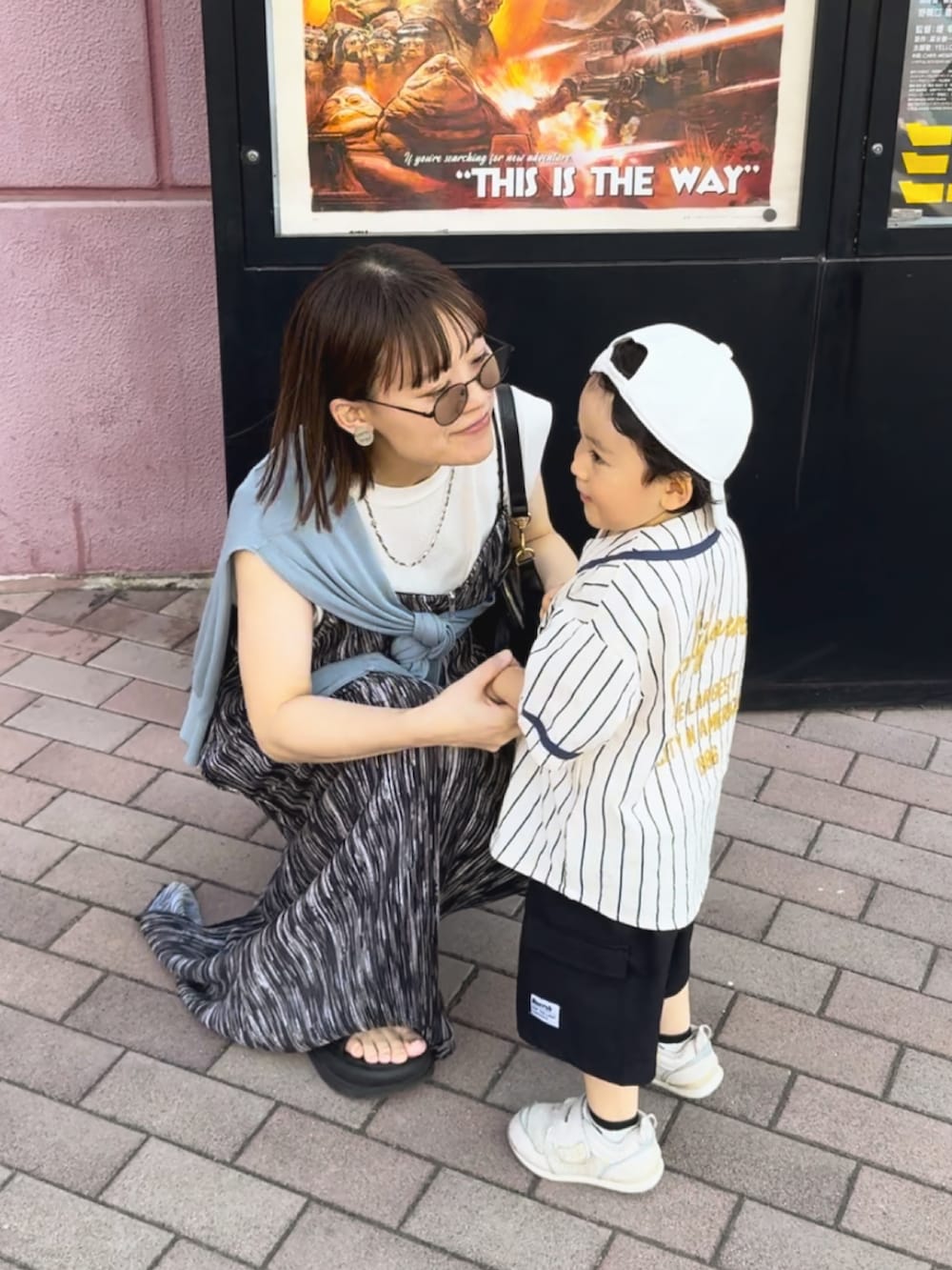 ブルー系のカーディガン/ボレロ、ブラック系のワンピース、ブラック系のバッグを着用したレディースの夏コーディネートの2枚目の写真