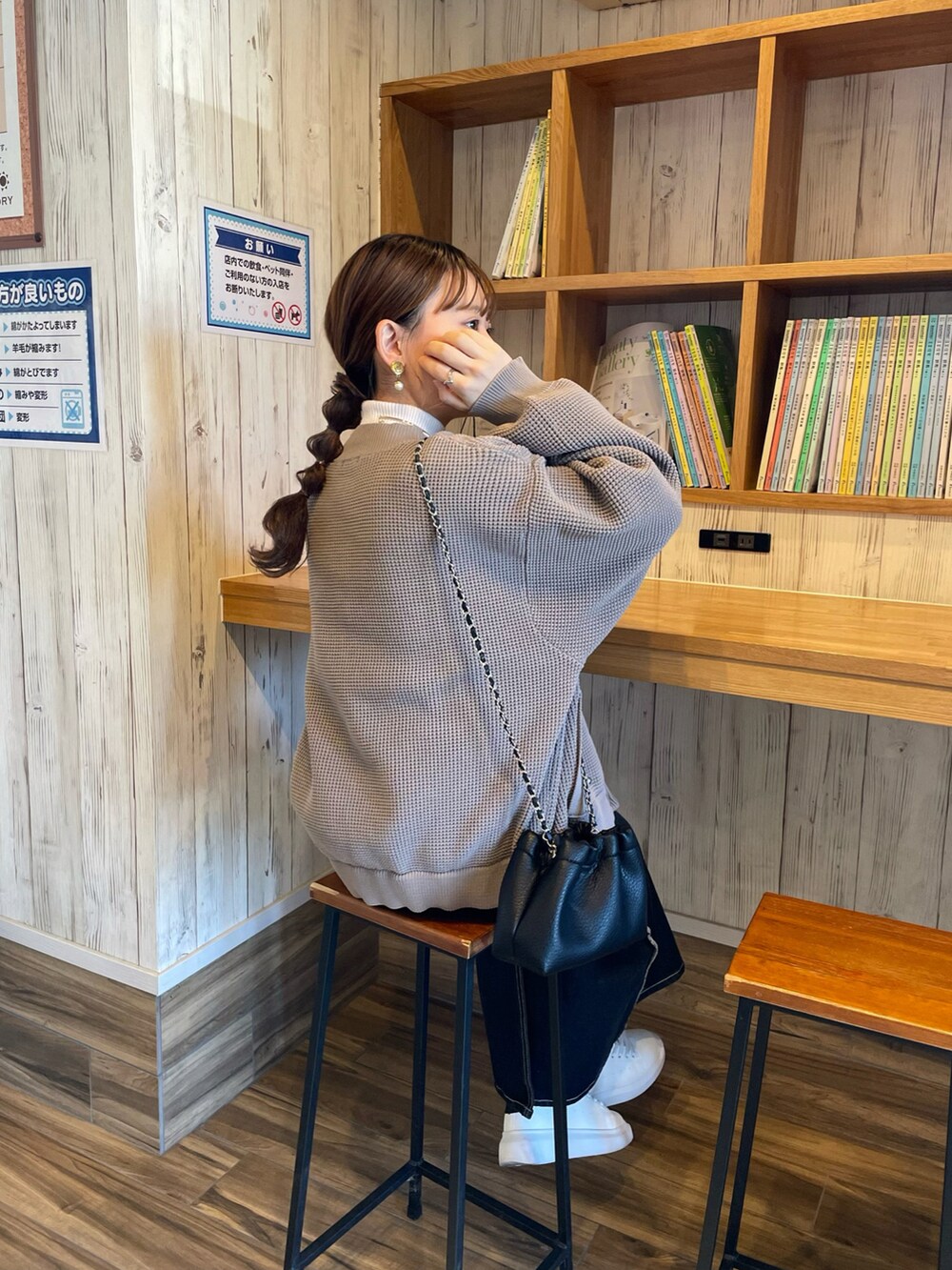 ブラウン系のカーディガン/ボレロ、ホワイト系のニット/セーター、ブラック系のデニムスカートを着用したレディースの冬コーディネートの2枚目の写真
