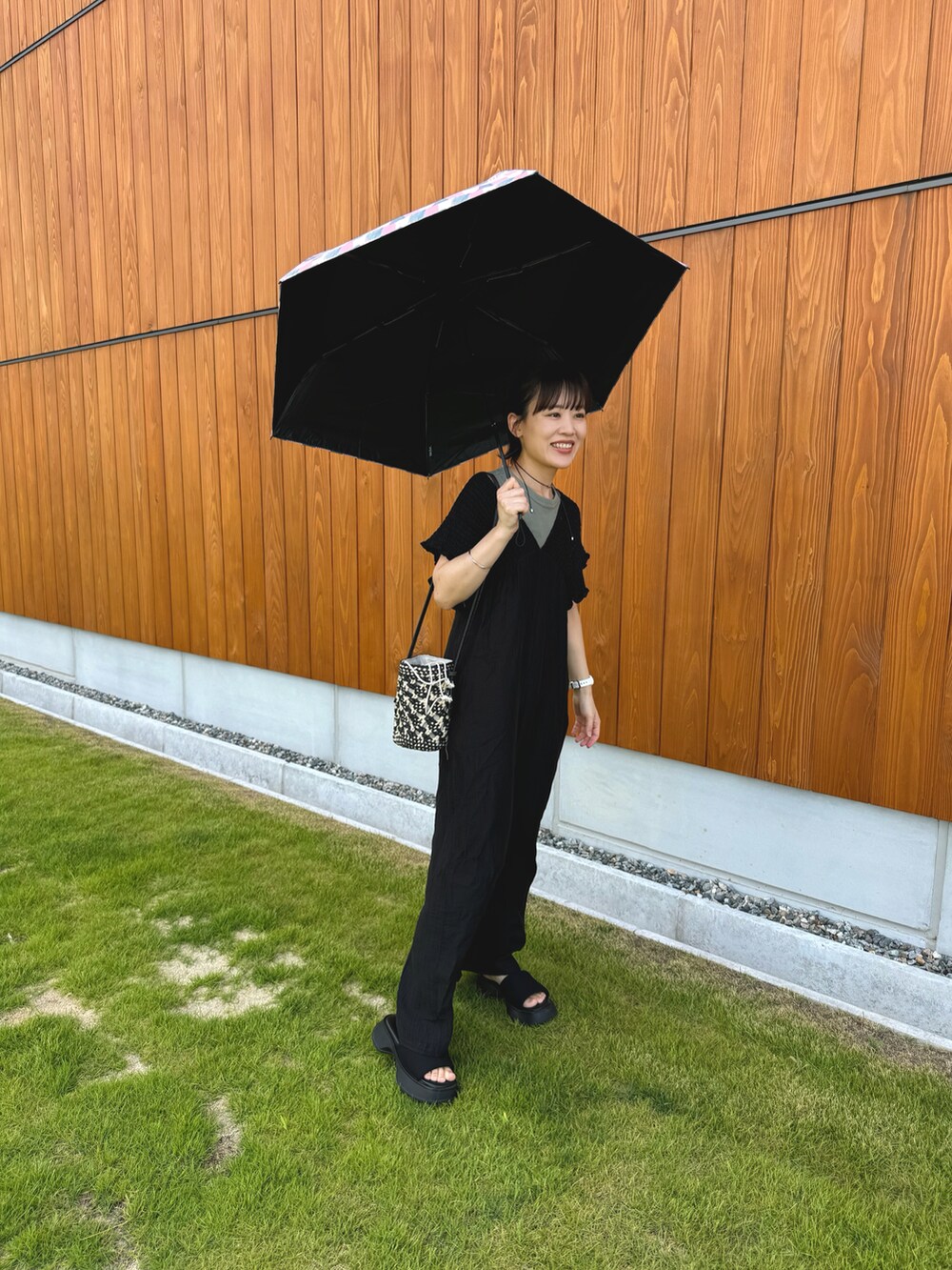 グリーン系のトップス、ブラック系のつなぎ/オールインワン、ブラック系のショルダーバッグを着用したレディースの夏コーディネートの5枚目の写真