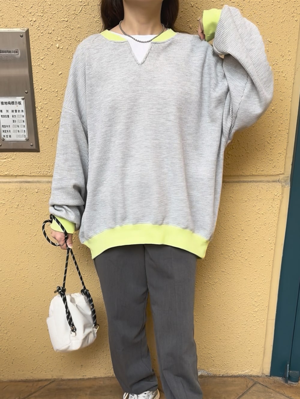 グレー系のTシャツ/カットソー、ベージュ系のスニーカー、グレー系のパンツを着用したレディースの春コーディネートの4枚目の写真
