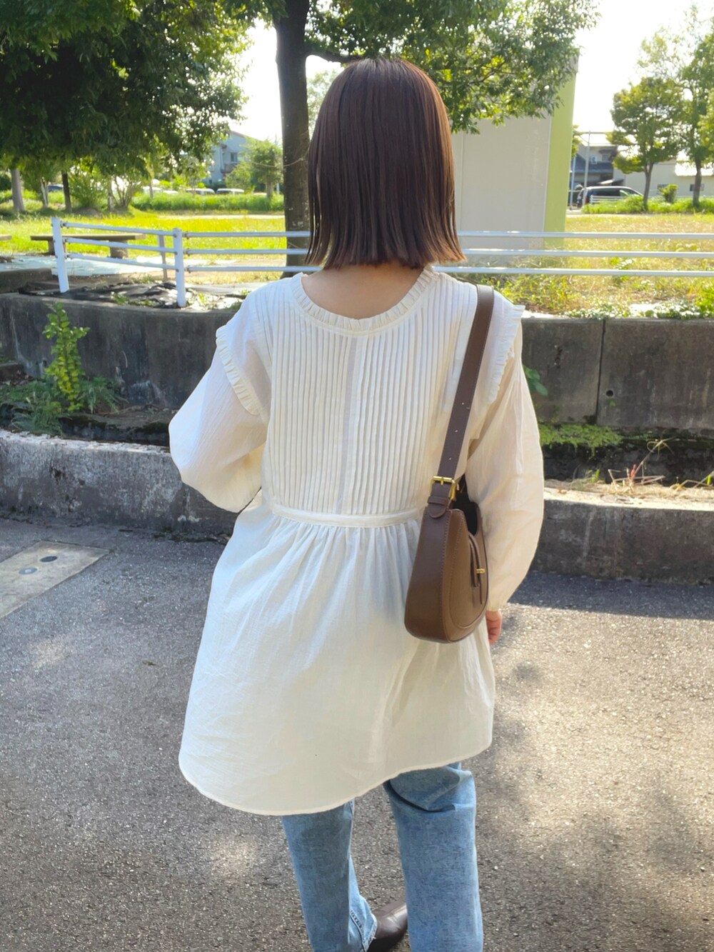 ベージュ系のシャツ/ブラウス、グレー系のベスト、ブラウン系のバッグを着用したレディースの秋コーディネートの5枚目の写真