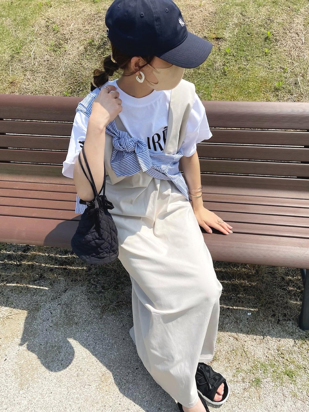 ベージュ系のジャンパースカート、ホワイト系のTシャツ/カットソー、ブルー系のシャツ/ブラウスを着用したレディースの夏コーディネートの4枚目の写真