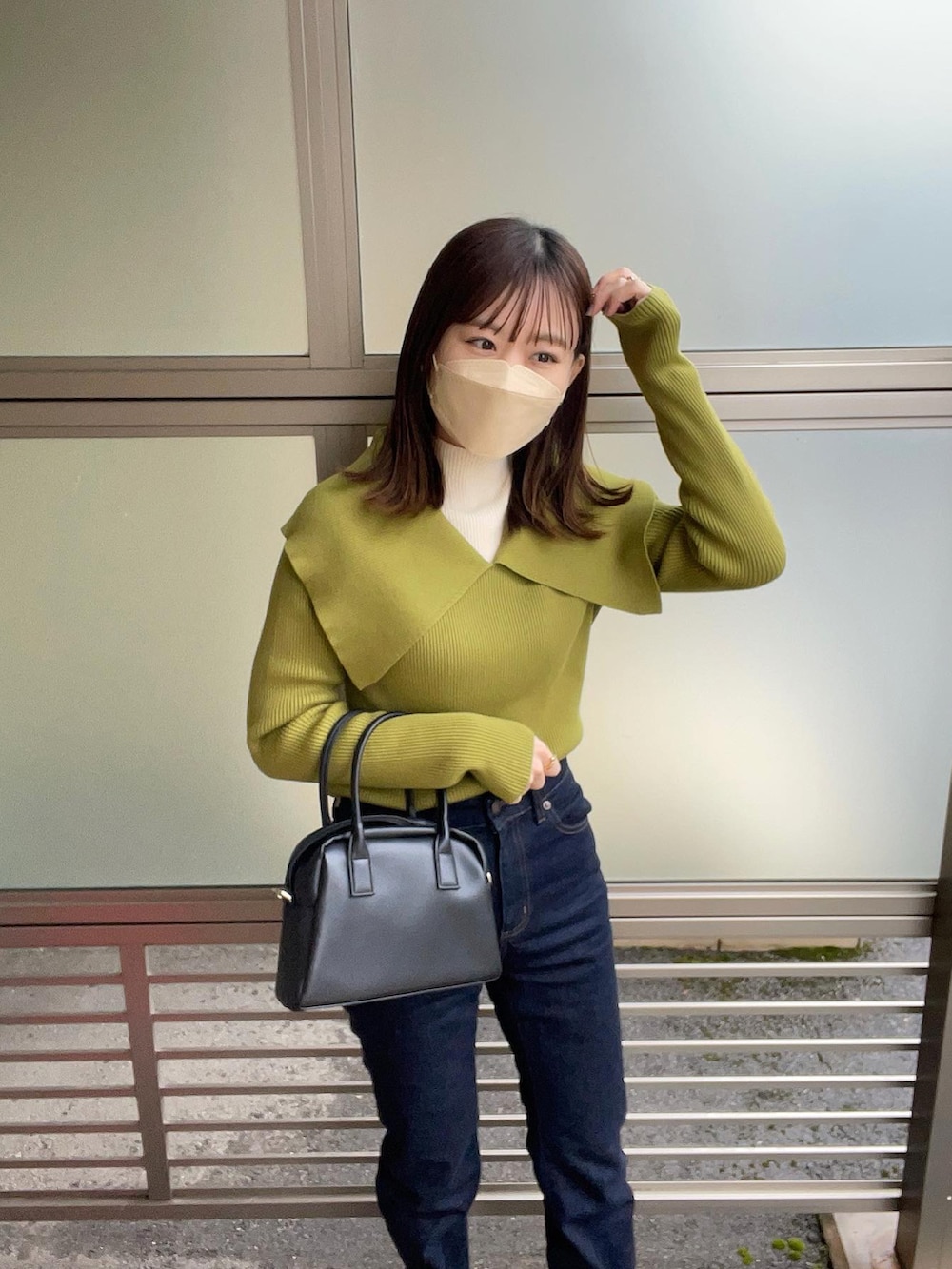 グリーン系のニット/セーター、ホワイト系のニット/セーター、ブルー系のデニムパンツを着用したレディースの冬コーディネートの5枚目の写真